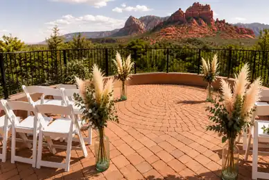 Sedona red rock ceremony space with white chairs and pampas grass arrangements