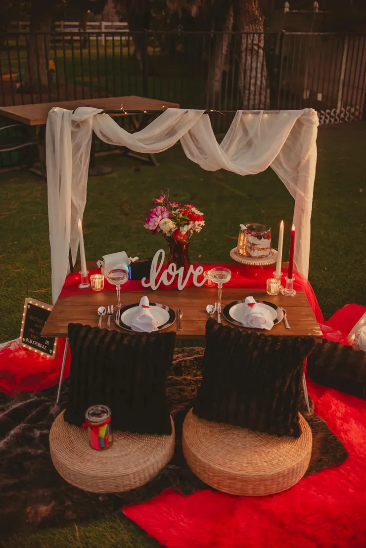 Romantic candlelit luxury picnic with love sign and floral centerpiece