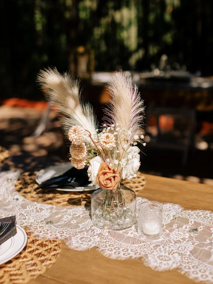 Boho centerpiece with pampas grass and dusty rose on lace runner