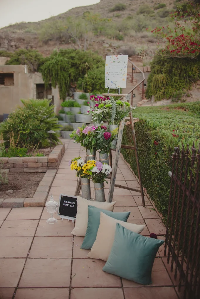 Spring Bloom Bar with floral ladder, tin vases and sage cushions on terracotta patio
