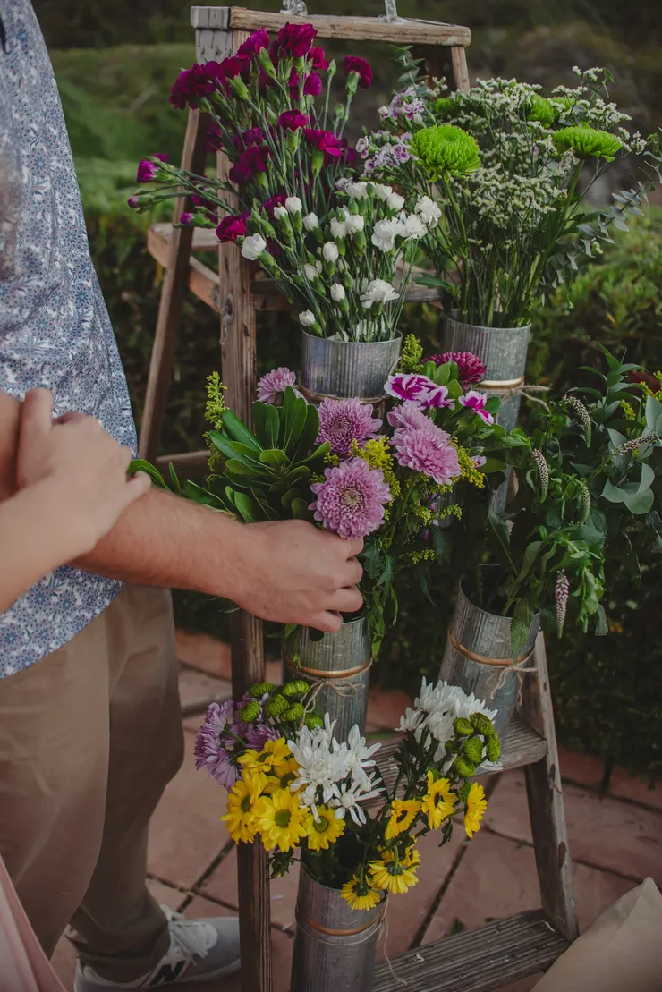 Bohemian floral ladder display with fresh blooms in tin vases